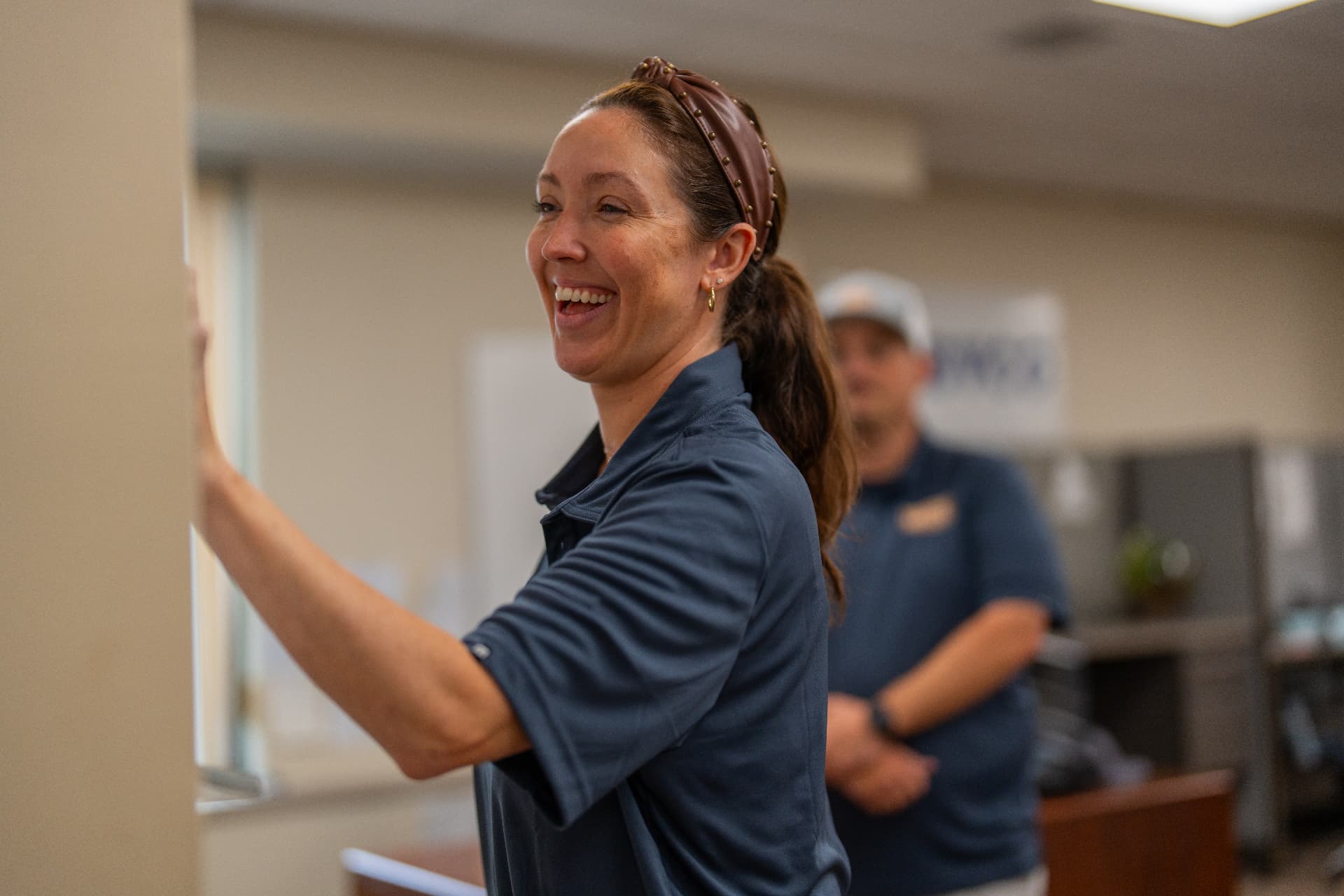 Smiling Levco team member at the office service window, ready to answer questions