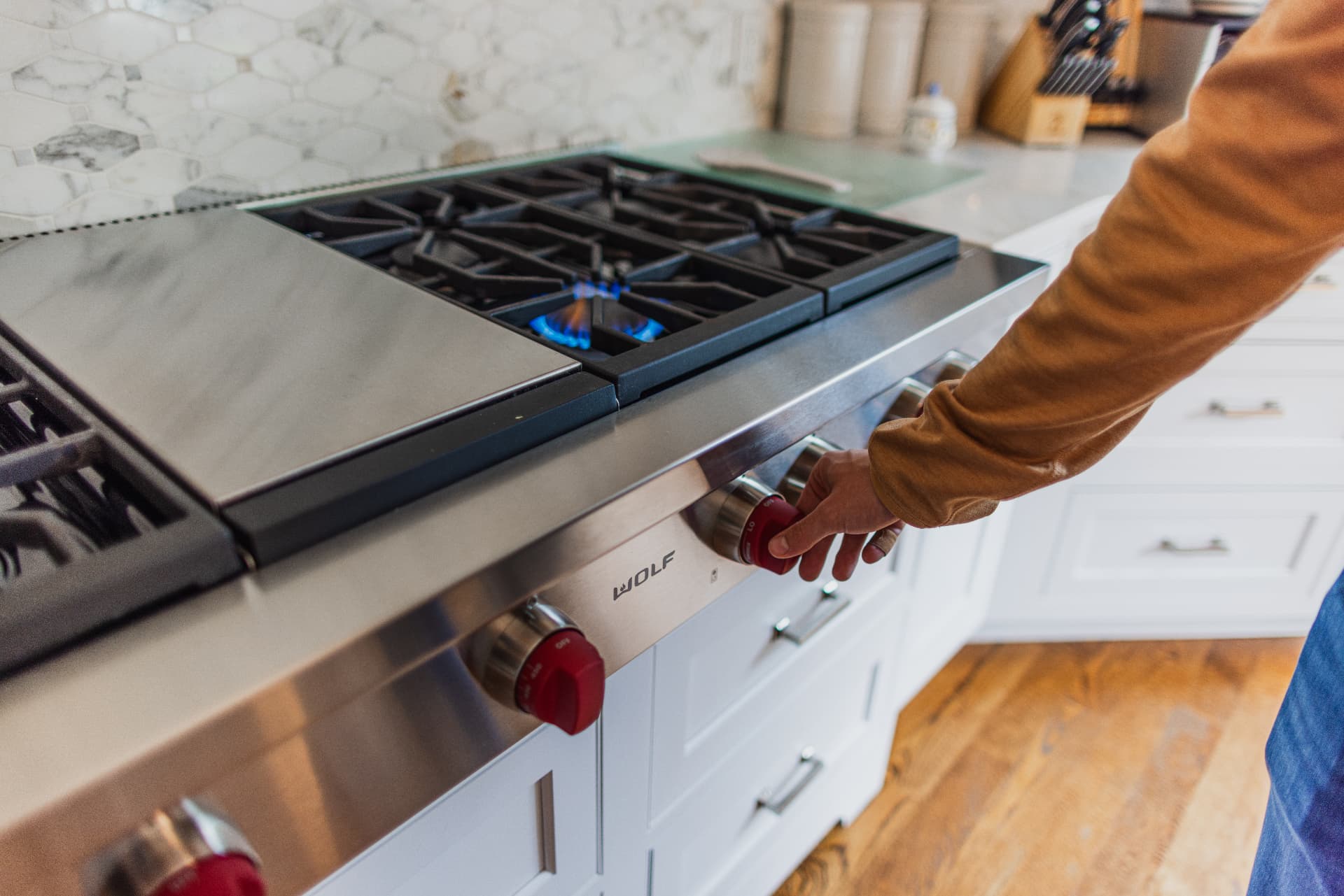 Homeowner turning on a propane cooking range in a Connecticut kitchen