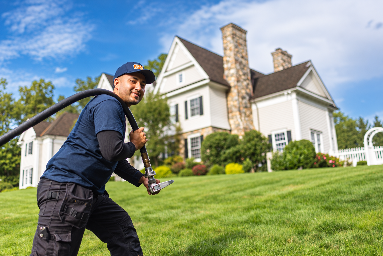 Levco propane technician carrying a delivery hose toward a Connecticut home