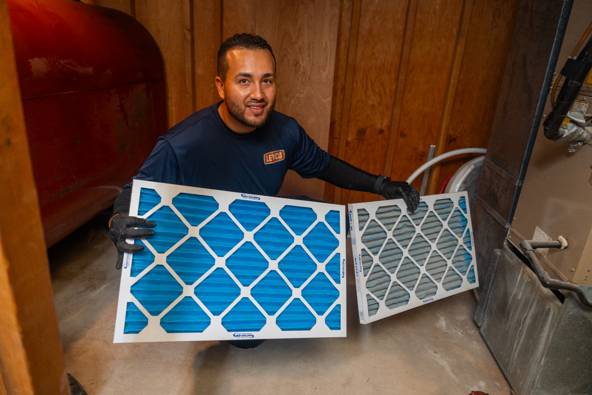 Levco technician comparing a clean air filter with the dirty filter it replaces