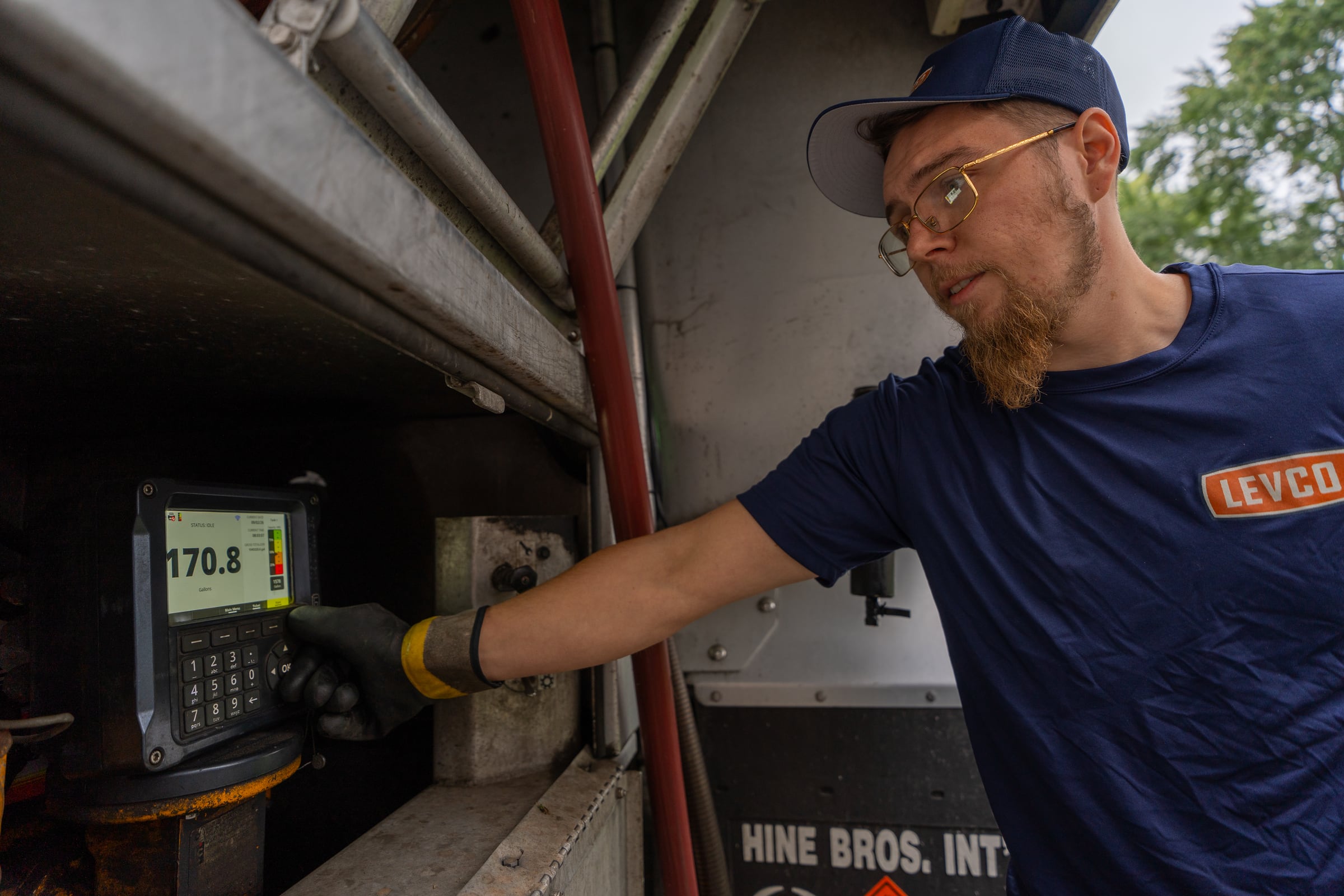 Levco driver confirming the metered gallons on a heating oil delivery truck