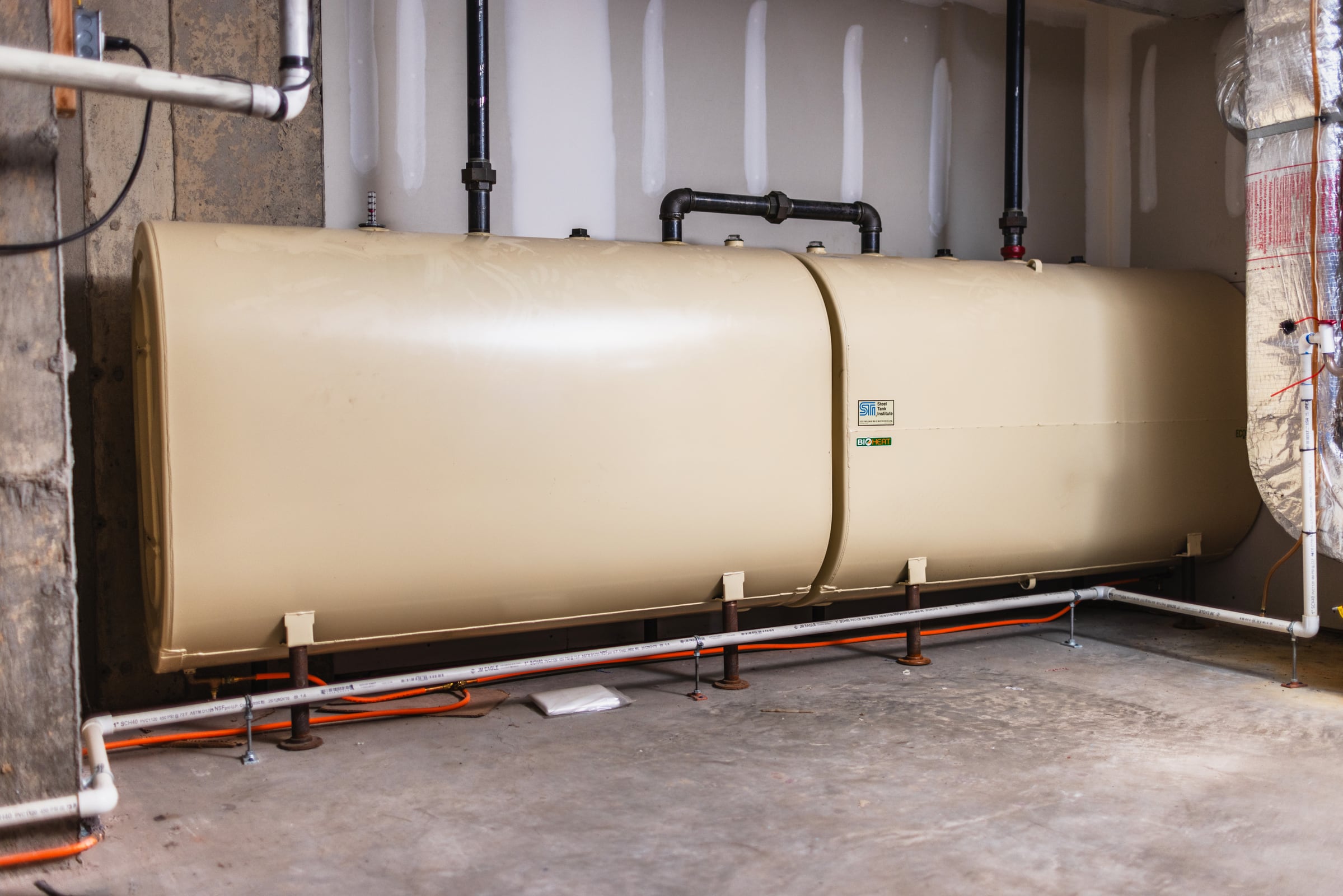 Newly installed pair of connected heating oil tanks with finished piping in a Connecticut basement